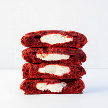 Load image into Gallery viewer, stack of two red velvet pudge cookies open, showing their cheesecake filling
